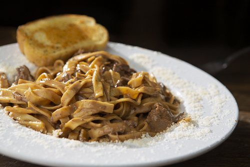 Slow Roasted Beef and gravy atop egg noodles served with garlic toast.