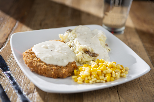 Seasoned breaded beef steak fried to perfection topped with white gravy, served with mashed potatoes and corn.