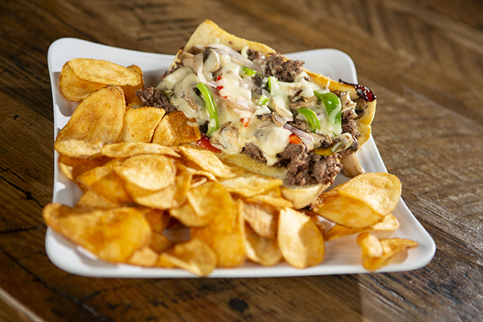 Thin Sliced beefsteak, sauteed peppers, onions and mushrooms topped with melty swiss cheese served on a hoagie bun, served with a side of chips.